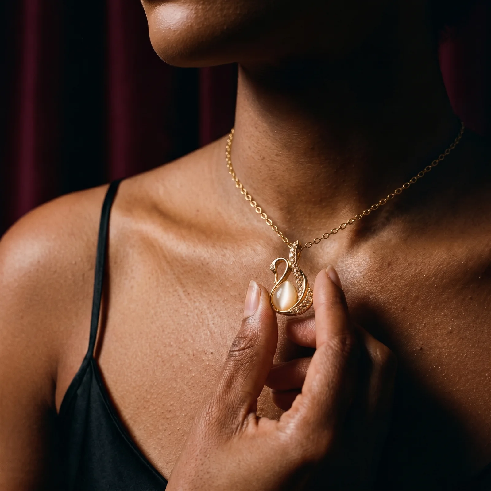 Perla Lune swan pendant held at the collarbone